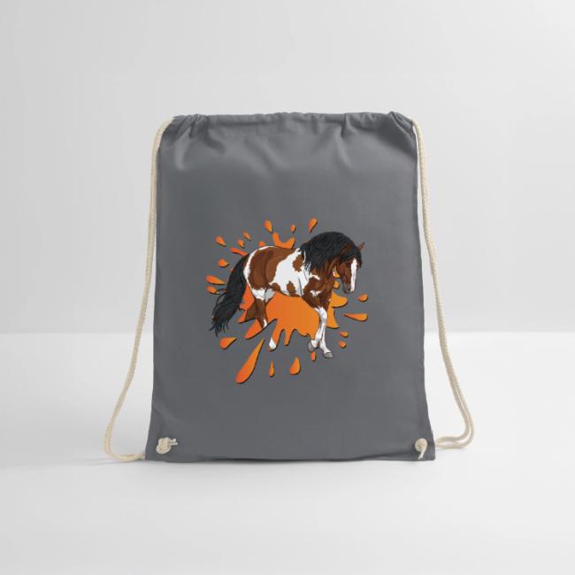 Un cheval pie devant une tache d'encre orange